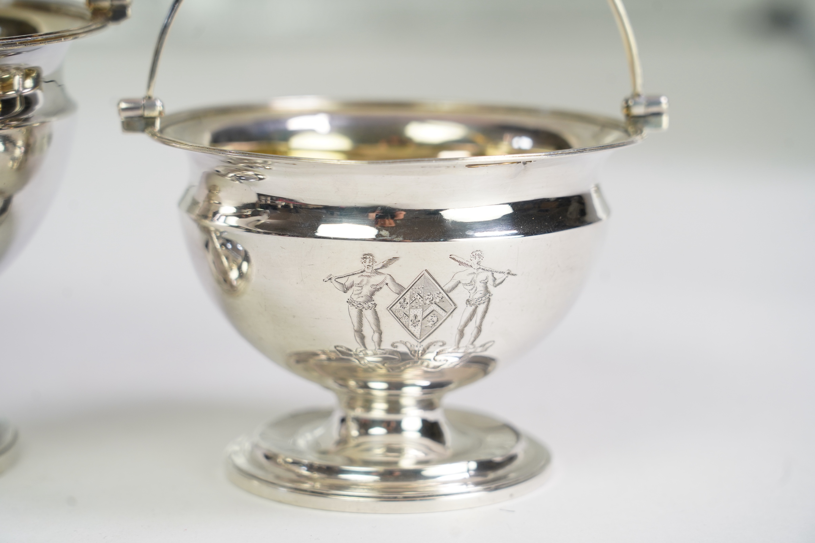 Two George III graduated silver pedestal sugar baskets, by James Darquits